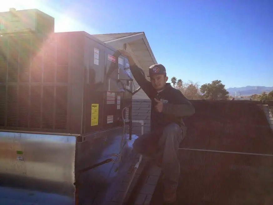 HVAC technician performing Boiler Repair on a rooftop unit in Posen